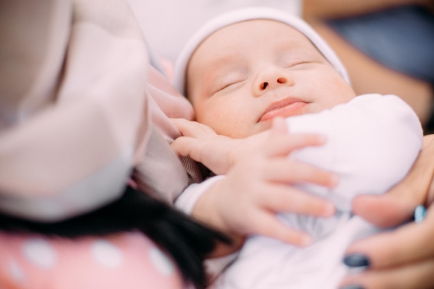 A mulher segura o bebê dormindo com força a vida dos braços