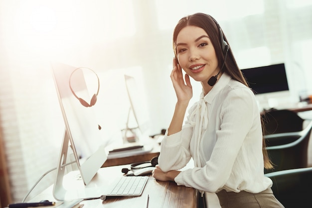 A mulher tem fones de ouvido em que fala aos clientes.