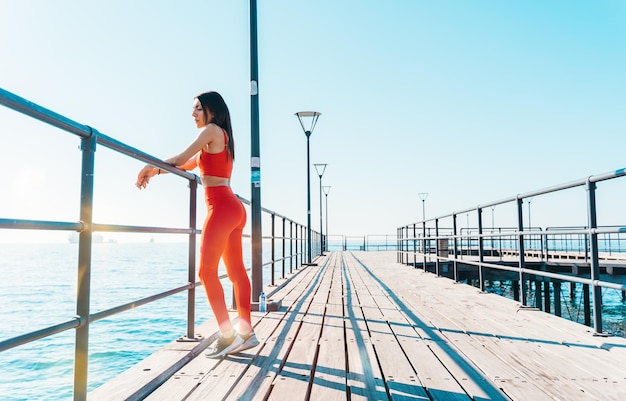 A mulher terminou de fazer fitness ao ar livre em frente ao mar