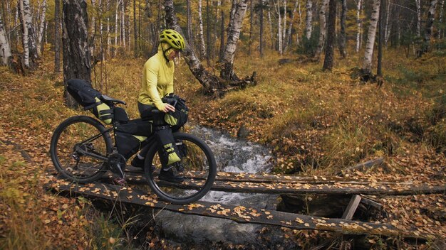 A mulher viaja em ciclismo de terreno misto com bikepacking