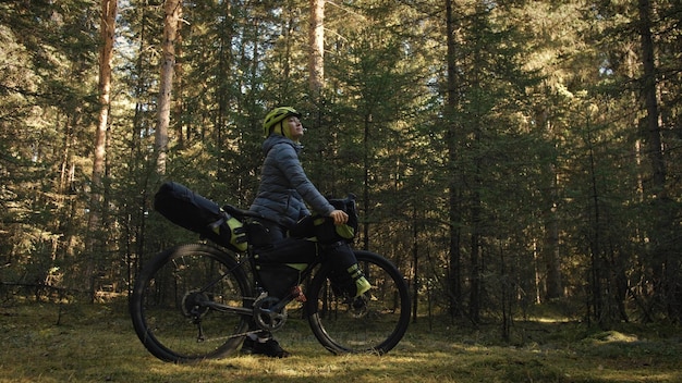 A mulher viaja em ciclismo de terreno misto com bikepacking