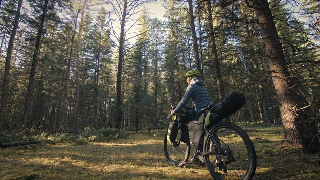 A mulher viaja em ciclismo de terreno misto com bikepacking