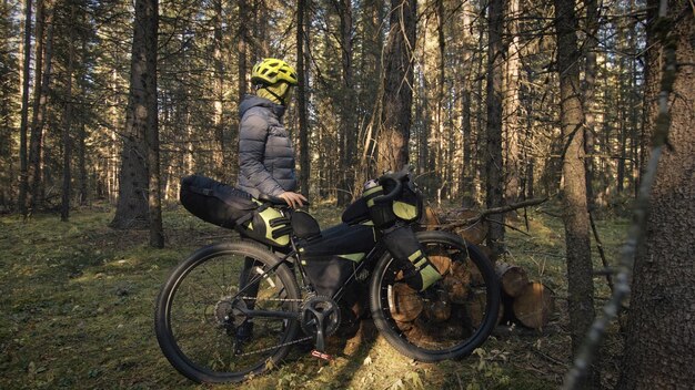 A mulher viaja em ciclismo de terreno misto com bikepacking