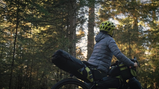 A mulher viaja em ciclismo de terreno misto com bikepacking