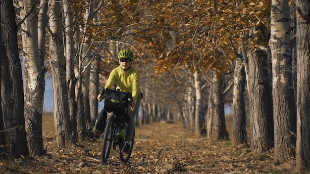 A mulher viaja em ciclismo de terreno misto com bikepacking