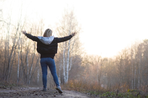 A natureza ao ar livre relaxa o conceito Mulher feliz com braços abertos