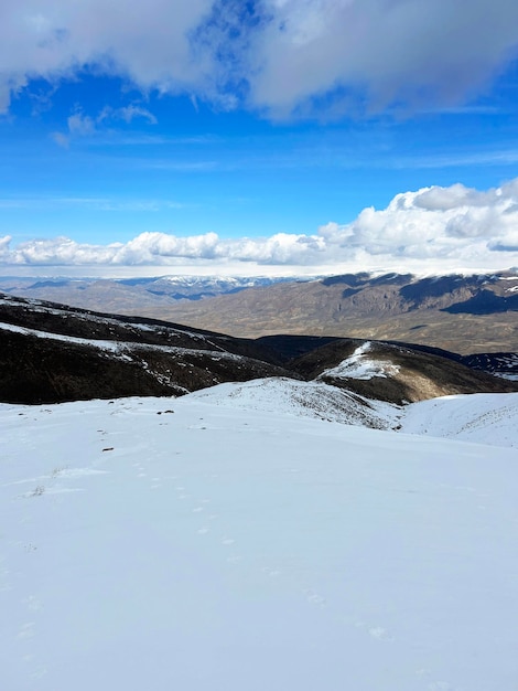 A neve do inverno cobria os picos das montanhas. A paisagem do inverno, as montanhas.