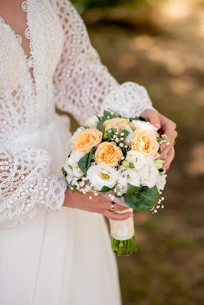 A noiva de vestido branco segura um buquê de flores nas mãos, ideia para agências de eventos de casamento