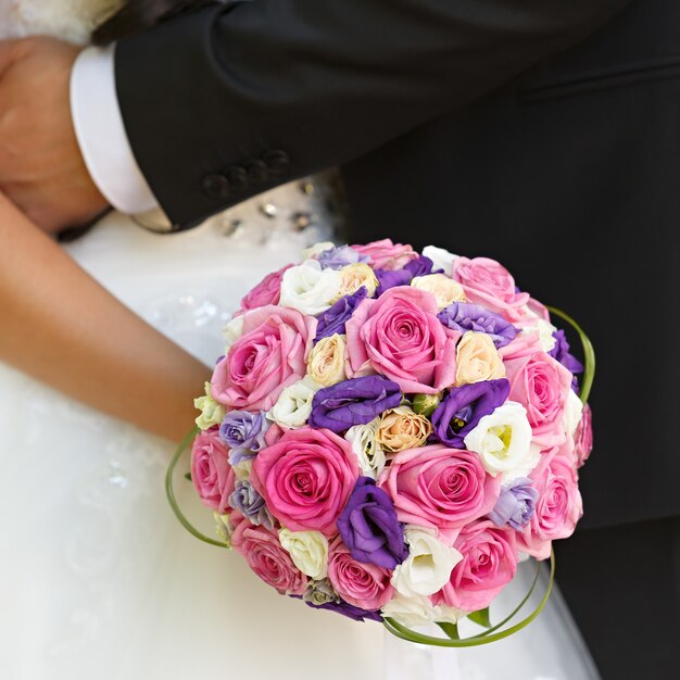 A noiva do casamento está segurando um buquê de flores