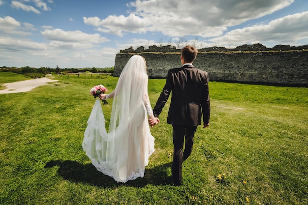 A noiva e o noivo com um buquê de casamento nas mãos na natureza Retrato de um casal atraente no país Cerimônia de casamento Recém-casados se casando ao ar livre