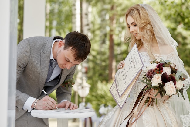 A noiva e o noivo registram seu casamento. Casamento na natureza. Amor para sempre