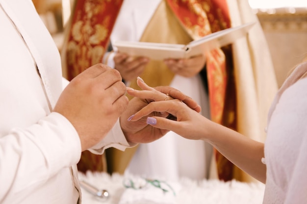 Foto a noiva e o noivo trocam alianças na igreja o sacramento do casamento