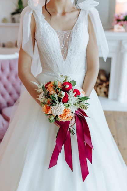 A noiva em um lindo vestido branco com um buquê nas mãos