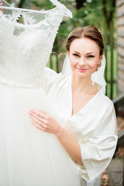 A noiva levanta o vestido de casamento do laço que levanta com ele fora