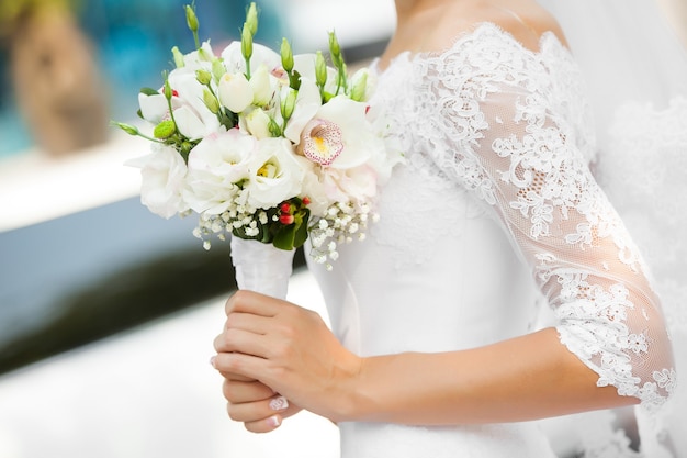 A noiva segura o lindo buquê de casamento