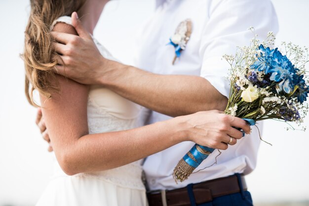 A noiva segura um buquê de casamento com flores azuis