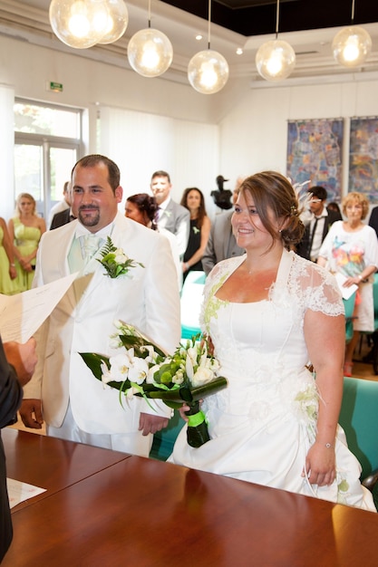 A noiva séria fica ao lado do noivo sorridente durante a cerimônia