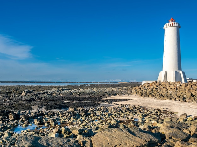 A nova torre ativa do farol de Akranes na península final na cidade sob o céu azul Islândia