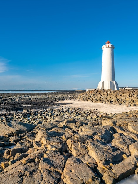 A nova torre ativa do farol de Akranes na península final na cidade sob o céu azul Islândia