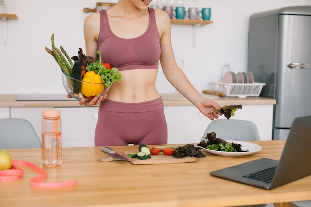 Foto a nutricionista do blogueiro atlética prepara uma salada com legumes frescos