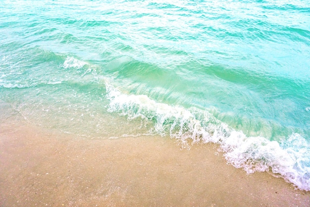 A onda de luz e o lindo mar verde com espaço para textos no fundo da praia..