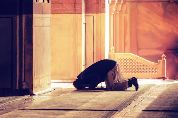 A oração muçulmana por Deus na mesquita. O velho muçulmano iraniano está de joelhos orando. Mês sagrado dos muçulmanos do Ramadã. Muçulmano, mohammedan, muslimah. monge, frade, monástico,