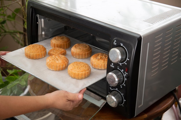 A padeira está pronta para assar o bolo de lua no forno.