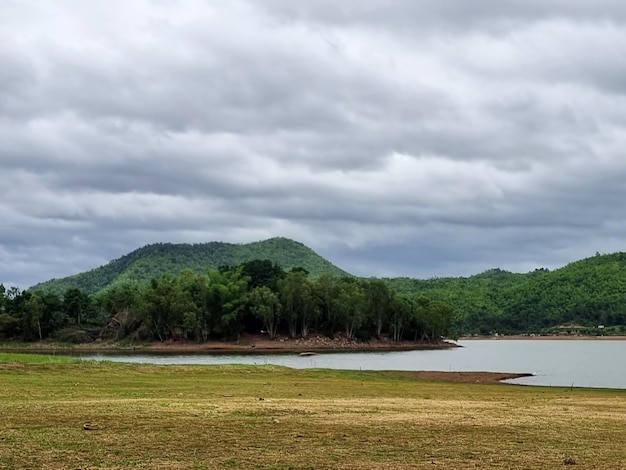 Foto a paisagem da montanha e do reservatório em nuvens nimbus no fundo do céu.