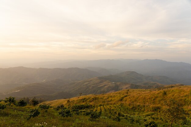 A paisagem de negligencia o campo da montanha no tempo do por do sol sobre o ponto de vista em Tailândia.