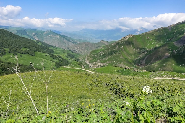 A paisagem do Aktoprak verde passa no Cáucaso a estrada e as montanhas sob nuvens cinzentas KabardinoBalkaria Rússia