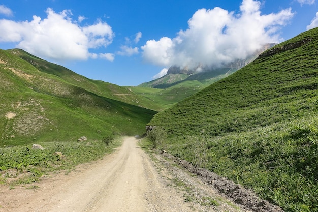 A paisagem do verde Aktoprak passa na estrada do Cáucaso e as montanhas sob nuvens cinzentas