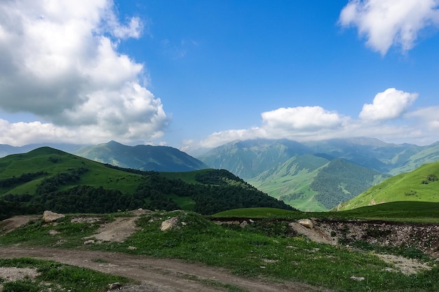 A paisagem do verde Aktoprak passa na estrada do Cáucaso e as montanhas sob nuvens cinzentas