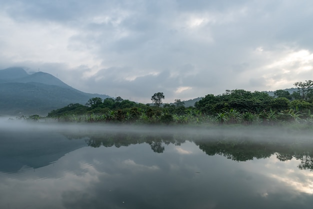A paisagem em ambos os lados do rio na névoa da manhã