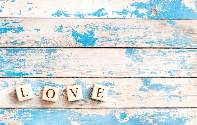 A palavra "amor" escrita com cubos de madeira com letras. Plano de fundo dia dos namorados.