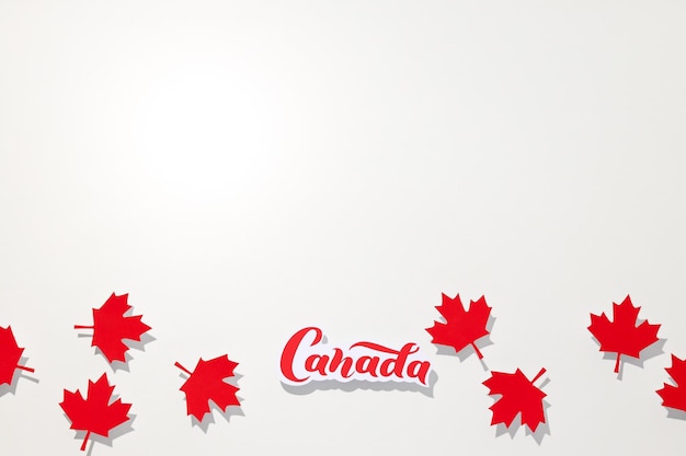 A palavra Canadá com folhas de bordo vermelhas em fundo branco