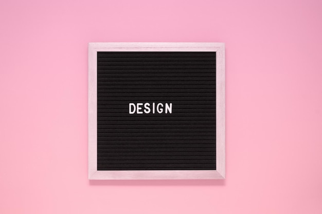 A palavra de design no quadro de letras preto sobre fundo rosa isolado