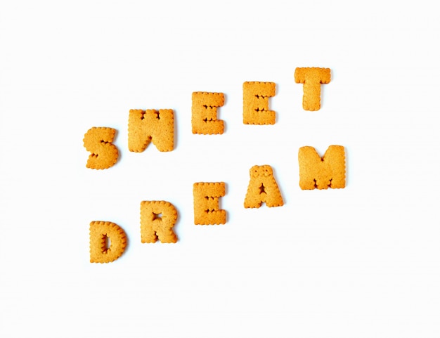 A palavra doce sonho escrito com biscoitos alfabeto isolado no fundo branco