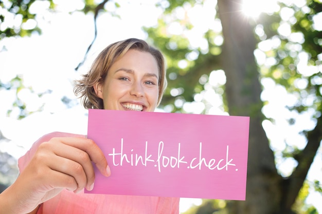 Foto a palavra pense.olhe.verifique. e mão segurando o cartão contra mulheres sorridentes correndo pela conscientização do câncer de mama
