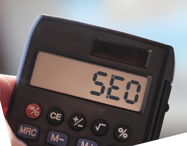 A palavra SEO acrônimo para Search Engine Optimization na exibição de uma calculadora Conceito de tecnologia de negócios