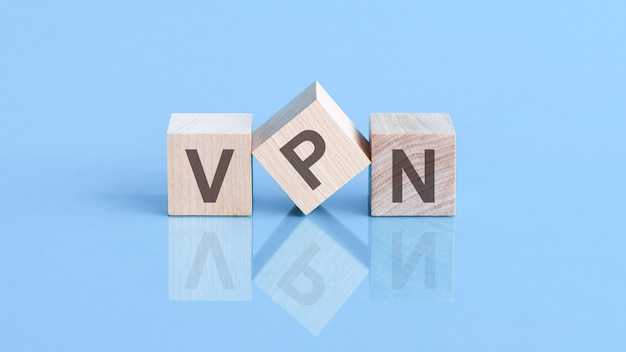 A palavra VPN é feita de cubos de madeira sobre a mesa azul, conceito