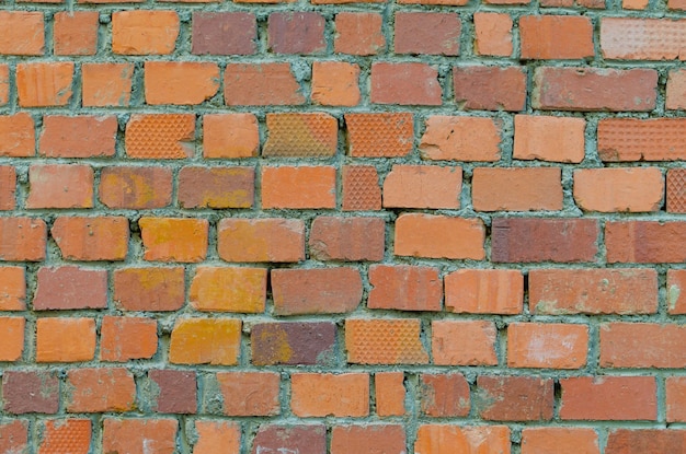 A parede é feita de tijolos de cores diferentes.
