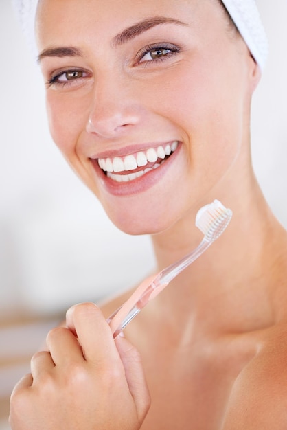 Foto a parte mais importante da minha rotina de beleza. uma linda jovem segurando uma escova de dentes enquanto sorria.