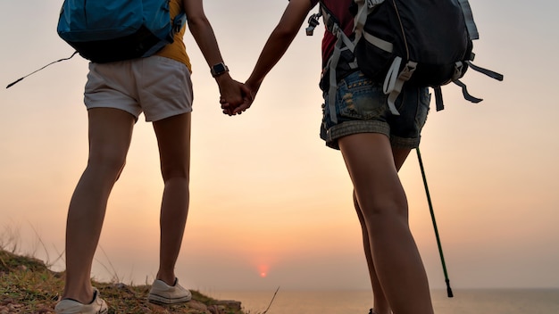 Foto a parte traseira de duas mulheres em pé no topo da montanha