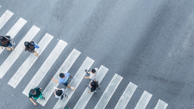 A partir da vista transversal superior de pessoas a pé na rua cruzamento pedonal na rua da cidade, vista aérea.