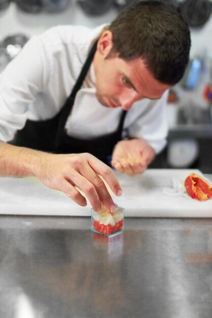 A perfeição está nos detalhes Um chef preparando cuidadosamente uma refeição gourmet