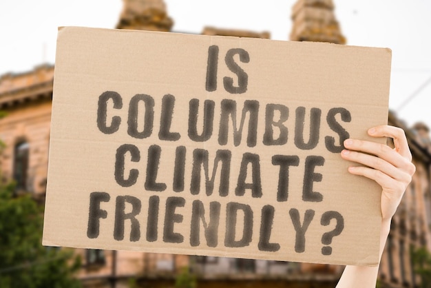 A pergunta Columbus é favorável ao clima está em uma faixa nas mãos dos homens com fundo desfocado Equipe de apoio Ativista Urban Sunset Carbon Ecology Energia Novo Limpo Aquecimento Resíduos