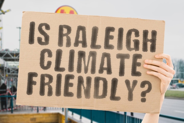 A pergunta é raleigh favorável ao clima está em um banner nas mãos dos homens com fundo desfocado equipe de apoio ativista urban sunset carbon ecology energia novo limpo aquecimento resíduos