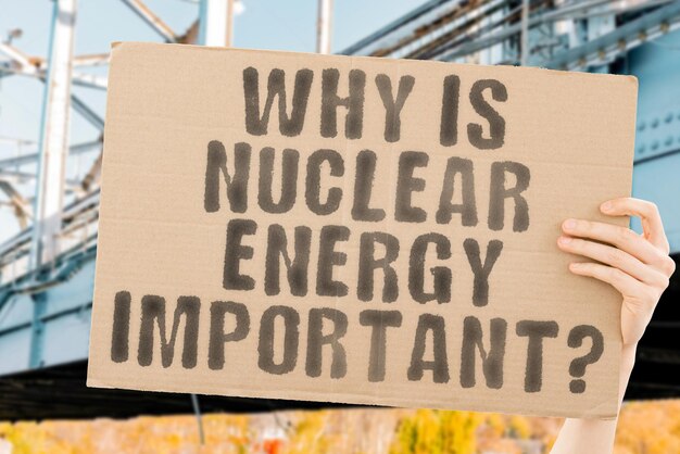 A pergunta Por que a energia nuclear é importante em um banner na mão dos homens Combustíveis fósseis sustentáveis