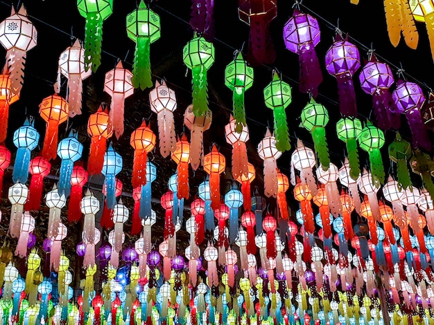 A perspectiva colorida e olha a vista das lanternas tailandesas do estilo Lanna para pendurar na frente do templo na noite no festival de Loy Kratong.