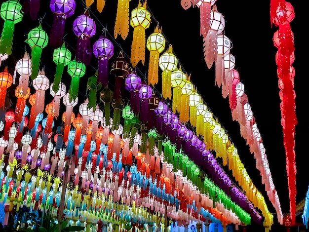 A perspectiva colorida e olha a vista das lanternas tailandesas do estilo lanna para pendurar na frente do templo na noite no festival de loy kratong.